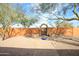 Backyard with gravel landscaping, flowers, an orange wall, and a brick path to a gate at 1301 E Belmont Ave, Phoenix, AZ 85020