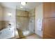 Bright bathroom featuring a glass-enclosed shower and a soaking tub at 1301 E Belmont Ave, Phoenix, AZ 85020