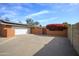 A large driveway leading to a two-car garage, accented by a vibrant bougainvillea at 1301 E Belmont Ave, Phoenix, AZ 85020