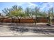 Street view of home with rock landscaping, desert trees, and orange wall with gate feature at 1301 E Belmont Ave, Phoenix, AZ 85020