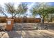 Front yard featuring desert landscaping, orange wall, and brick steps leading to a wood gate at 1301 E Belmont Ave, Phoenix, AZ 85020