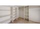 Spacious walk-in closet featuring built-in shelving and tile flooring at 13439 N 16Th Ave, Phoenix, AZ 85029