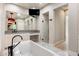 Bathroom with a soaking tub, dual vanities, large mirror, walk-in shower with matte black fixtures and glass door at 13763 N Campsite Ct, Fountain Hills, AZ 85268