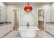 Bathroom featuring a soaking tub, dual vanities with stone countertops, modern lighting and tile floors at 13763 N Campsite Ct, Fountain Hills, AZ 85268