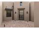 A modern entry with a sleek metal-framed door set in a stucco wall with desert landscaping at 13763 N Campsite Ct, Fountain Hills, AZ 85268