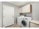 Laundry room with white washer and dryer and storage cabinets at 14430 W White Rock Dr, Sun City West, AZ 85375