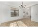 Bright living room with neutral tile, white walls, large windows, and modern chandelier at 14430 W White Rock Dr, Sun City West, AZ 85375