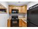 Efficient kitchen with black appliances and wood-tone cabinets at 1546 W Polk St, Phoenix, AZ 85007