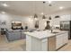 Open-concept kitchen featuring a large island, pendant lighting, and stainless steel appliances overlooking the living room at 15667 W Mercer Ln, Surprise, AZ 85379