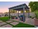 Beautiful backyard pergola with stylish seating and artificial turf, creating an inviting outdoor space at 15667 W Mercer Ln, Surprise, AZ 85379