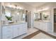 Well-lit bathroom with double vanities, modern fixtures, and elegant tile work at 15683 W Mercer Ln, Surprise, AZ 85379