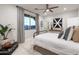 This bedroom features a large window with a view, ceiling fan, and decorative touches at 15683 W Mercer Ln, Surprise, AZ 85379