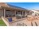 Entertain on this outdoor covered patio with comfortable seating, desert landscape, and solar panels at 15701 W Huron Dr, Sun City West, AZ 85375