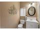 Bathroom with an oval mirror, toilet, and sink with wall decor for a nice touch at 15701 W Huron Dr, Sun City West, AZ 85375