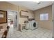 Functional laundry room with washer, dryer, storage cabinets, and desk area at 15701 W Huron Dr, Sun City West, AZ 85375