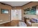 Sitting room showcasing views of other rooms in the house with comfortable seating, wood floors, and a tapestry on the wall at 15701 W Huron Dr, Sun City West, AZ 85375