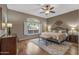 Comfortable main bedroom features a ceiling fan, a window with shutters, and an area rug over hardwood floors at 15701 W Huron Dr, Sun City West, AZ 85375