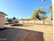 View of the spacious backyard with a brick patio, a trampoline, and a block wall at 1636 E Marigold St, Casa Grande, AZ 85122