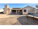 View of the backyard, featuring a covered patio, solar panels, and a spacious dirt lot at 1636 E Marigold St, Casa Grande, AZ 85122