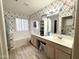 Well-lit bathroom with a soaking tub, dual sinks, floral wallpaper, and plenty of storage at 1636 E Marigold St, Casa Grande, AZ 85122