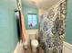 Bright bathroom featuring a decorative shower curtain, white wainscoting, and wood-look floors at 1636 E Marigold St, Casa Grande, AZ 85122