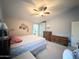 Inviting bedroom featuring a ceiling fan, soft lighting, and ample storage space with wooden dressers at 1636 E Marigold St, Casa Grande, AZ 85122