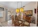 Bright dining area with glass table, rattan chairs, pendant lights, and access to the patio at 1651 E Kielly Ln, Casa Grande, AZ 85122