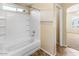 Clean bathroom with a white tiled shower and tub, featuring a shower head and shelves at 1655 W Wilson Ave, Coolidge, AZ 85128