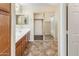 Bright bathroom featuring a double sink vanity, tiled floor and mirrored closet at 1655 W Wilson Ave, Coolidge, AZ 85128