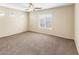 Well-lit bedroom featuring carpeted floors, a ceiling fan, and a large window at 1655 W Wilson Ave, Coolidge, AZ 85128