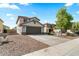 Two-story home featuring a two-car garage, desert landscaping, and a 'For Sale' sign on a sunny day at 1655 W Wilson Ave, Coolidge, AZ 85128