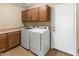 Laundry room featuring a full-sized washer and dryer, overhead cabinets, and tile flooring at 1655 W Wilson Ave, Coolidge, AZ 85128