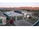 An aerial view of a home with a tile roof and solar panels, plus mountain views in the background at 18024 E Wolf Tree Ln, Rio Verde, AZ 85263