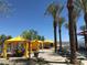 Poolside cabanas with curtains provide shade and privacy, lined with palm trees and lounge chairs under a clear blue sky at 18024 E Wolf Tree Ln, Rio Verde, AZ 85263