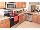 Kitchen with stainless steel appliances, range with ceramic cooktop, granite counters and tiled backsplash at 1813 N Lewis Pl, Casa Grande, AZ 85122