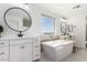 Bright bathroom featuring dual vanities, a soaking tub, and stylish modern fixtures at 18609 W Diana Ave, Waddell, AZ 85355