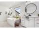 Bright bathroom featuring dual vanities, a soaking tub, and stylish modern fixtures at 18609 W Diana Ave, Waddell, AZ 85355