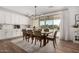 Elegant dining room with a view of the backyard and white kitchen cabinets at 18609 W Diana Ave, Waddell, AZ 85355