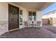 Inviting front porch features a seating area, decorative wreath, and covered entrance at 18609 W Diana Ave, Waddell, AZ 85355