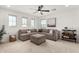 Comfortable living room featuring a sectional sofa, ottoman, and large windows at 18609 W Diana Ave, Waddell, AZ 85355