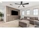 Comfortable living room featuring a sectional sofa, ottoman, and large windows at 18609 W Diana Ave, Waddell, AZ 85355