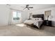 Bright main bedroom with a ceiling fan, large window, carpet, and neutral decor at 18609 W Diana Ave, Waddell, AZ 85355