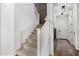 Carpeted staircase with white banister and dark wood paneled wall at 18609 W Diana Ave, Waddell, AZ 85355