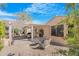 A view of the backyard with a covered patio, fire pit, and gravel landscaping at 18668 N Lariat Ct, Surprise, AZ 85387