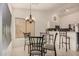 Open dining area with a glass table, chandelier, and breakfast bar connecting to the modern kitchen at 1973 E Buena Vista Dr, Chandler, AZ 85249