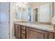 Bathroom featuring double sinks with granite countertops and wooden cabinets at 20187 E Sonoqui Blvd, Queen Creek, AZ 85142