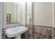 Elegant powder room featuring a pedestal sink and decorative tile accents at 20187 E Sonoqui Blvd, Queen Creek, AZ 85142