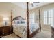 Comfortable bedroom featuring a four-poster bed, plush carpet, and plantation shutters at 20187 E Sonoqui Blvd, Queen Creek, AZ 85142