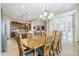 Open dining room with a wooden table, chandelier, and a kitchen with stainless steel appliances at 20187 E Sonoqui Blvd, Queen Creek, AZ 85142