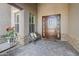 Cozy front porch with a decorative wood bench, plants, and a charming wood and glass front door at 20187 E Sonoqui Blvd, Queen Creek, AZ 85142